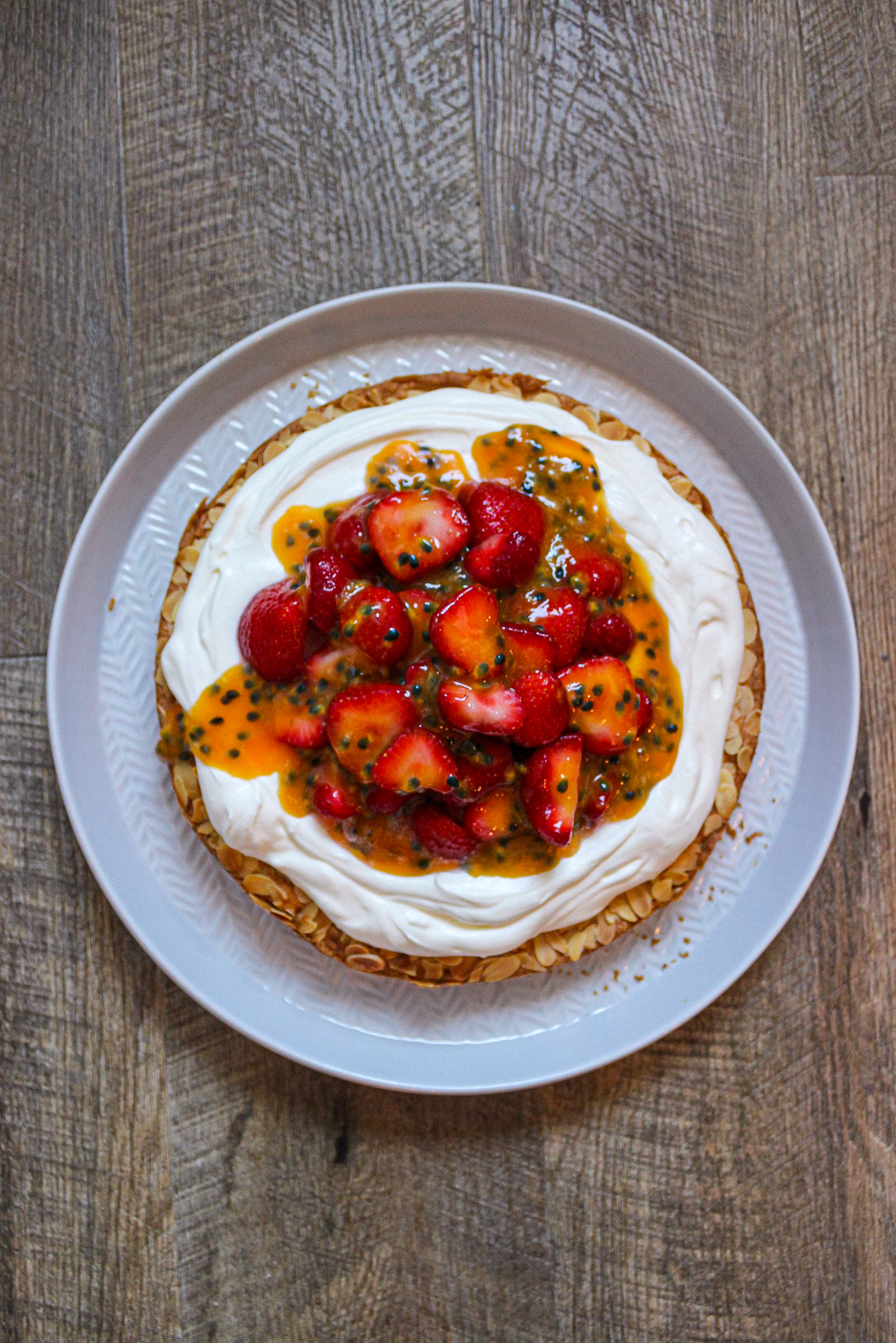 Ein knuspriger Mandelkuchen mit Erdbeeren, einer Sahnecrème und fruchtigem Passionsfruchtgelee. Ideal für die nächste sommerliche Kaffeetafel.